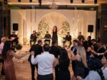 Kürtçe düğünde halay çeken davetliler ve sahnedeki canlı müzik ekibi